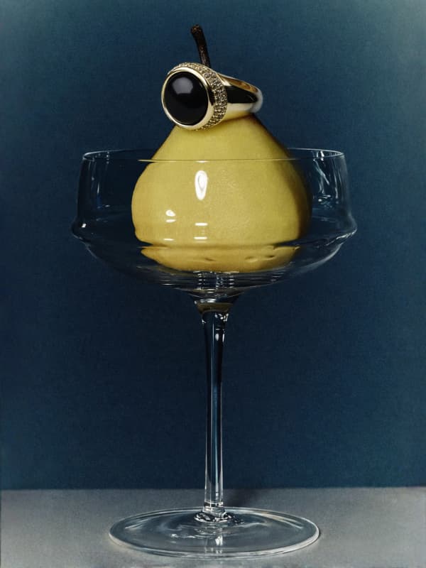 Pear-shaped cocktail in a glass with a black ring on a dark blue background