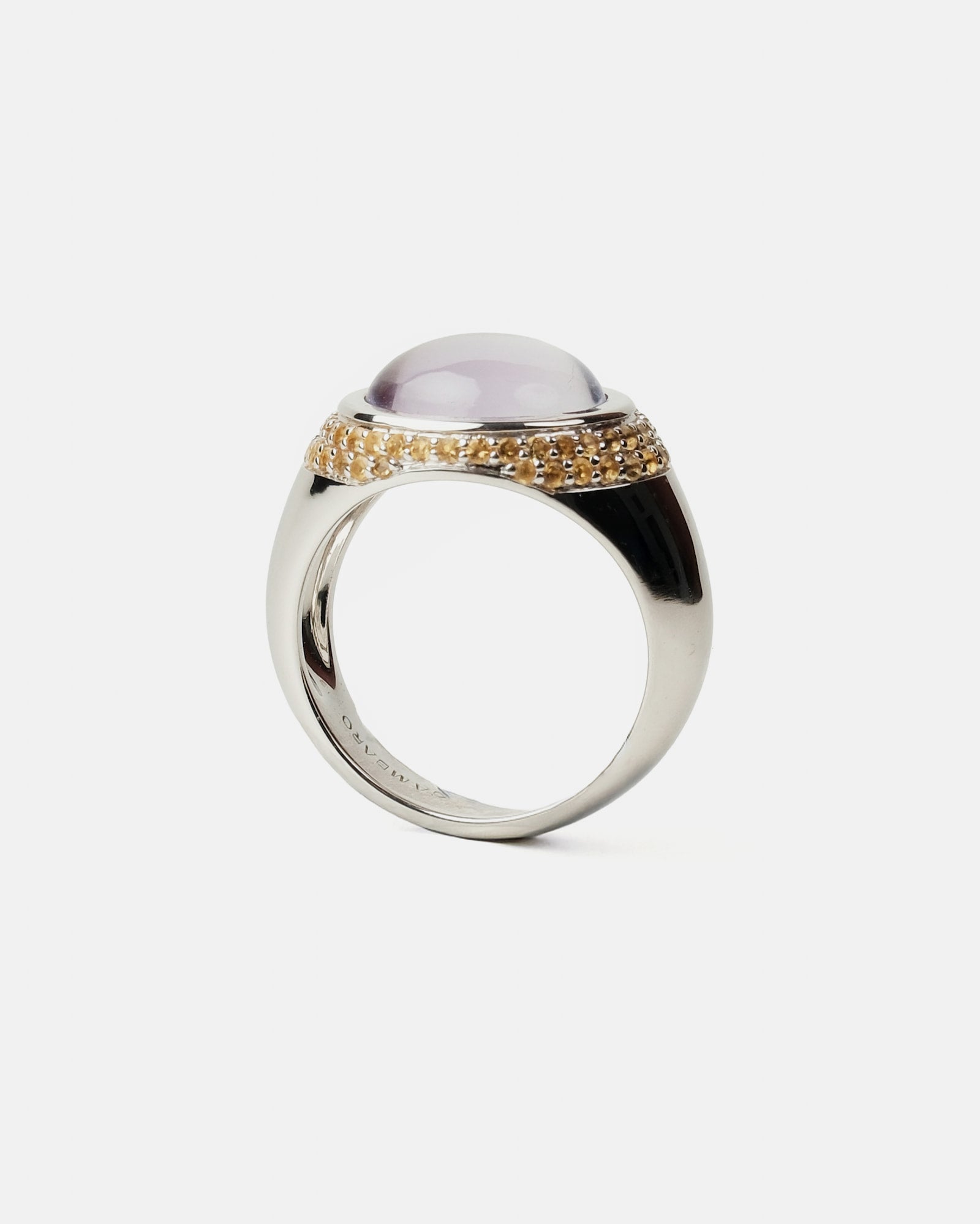 Silver ring with a purple gemstone and gold accents on a white background